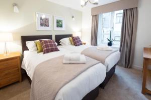 een slaapkamer met 2 bedden en een raam bij The Malt Kiln Apartment Edinburgh Old Town 3 Bedroom Parking previously McDonald Residence in Edinburgh