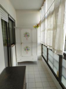 a white cabinet in a room with windows at Casa de Praia da Lú in Figueira da Foz +3 photos
