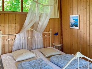 een slaapkamer met 2 bedden en een klamboe bij 4 person holiday home in Stege in Pollerup Kullegård
