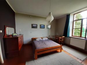 a bedroom with a bed and a dresser and a window at Le Thirifays in Chiny
