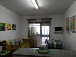 a living room with a couch and a table at Casa de Praia da Lú in Figueira da Foz