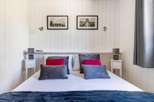 a bedroom with a large bed with red and blue pillows at Les minis homes du Bugey - Eco-lodge City, un refuge en hyper centre in Ambérieu-en-Bugey