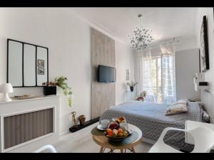 - une chambre avec un lit et une table avec des fruits dans l'établissement La Croisette - Superbe studio au mythique Palais Miramar, à Cannes