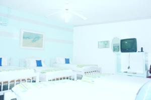 a white room with white chairs and a tv at Hotel Ivania´s in Masaya