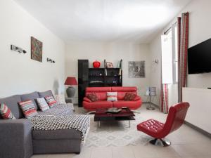 a living room with a red couch and a red chair at Cosy Holiday Home in Provence with Swimming Pool in Rasteau