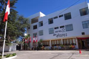 un bâtiment avec drapeaux devant lui dans l'établissement Hotel Las Flores, à Ica