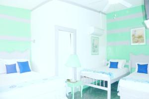 Duas camas num quarto branco com paredes azuis em Hotel Ivania´s em Masaya