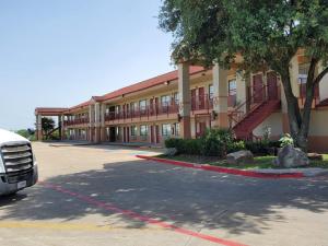 a building with a truck parked in a parking lot at Express Inn in Dallas