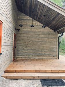 a screened porch with wooden flooring on a house at Sklandas in Bernāti