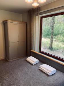 Zimmer mit Fenster und 2 Handtüchern auf dem Boden in der Unterkunft Roze Guest Houses Sklandas in Bernāti