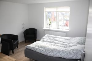 1 dormitorio con 1 cama y 2 sillas en Skibbild Bed no Breakfast en Herning