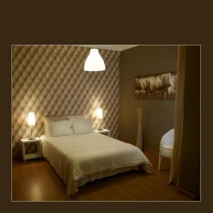 a bedroom with a large bed with a tufted headboard at RESIDENCIAL RITA in Odemira