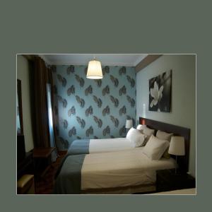a hotel room with a bed and a lamp at RESIDENCIAL RITA in Odemira