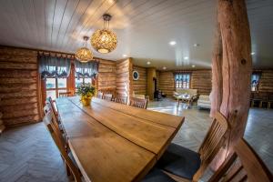 LīvāniBrīvdienu māja "Avotiņš"的木墙客房内的大木桌
