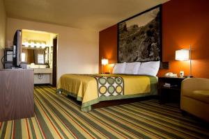 una camera d'albergo con letto e TV di Super 8 by Wyndham Woodward a Woodward