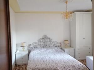 1 dormitorio con 1 cama blanca y 2 mesitas de noche en Antico Borgo, en Bagnoregio