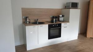 a kitchen with white cabinets and a black oven at L escapade amoureuse in Bournezeau