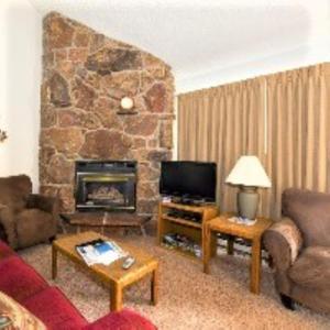 sala de estar con sofá y chimenea en Twin Rivers By Alderwood Colorado Management, en Fraser