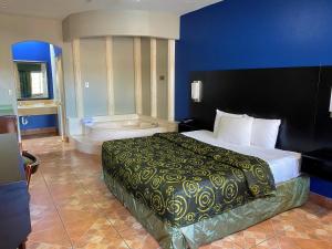 Habitación de hotel con cama y bañera en Texas Inn Alamo, en Alamo