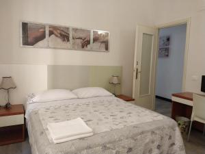 a bedroom with a bed with two towels on it at Affittacamere La Spezia Inn in La Spezia