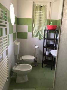 フィナーレ・リーグレにあるAppartamento Alessandraの緑と白のバスルーム(トイレ、シンク付)