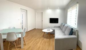 a living room with a couch and a table at Apartmani GO Bugojno in Bugojno