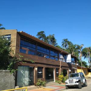 um edifício com um camião estacionado em frente dele em Joaquina 433 - Pousada Floripa em Florianópolis
