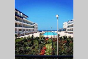 vistas a una playa con edificios y luz de la calle en Pieds dans l'eau, piscine face à la mer - Adan beach - entre Agadir et Taghazout, en Agadir