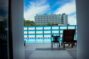 a balcony with a table and chairs and a building at Baan Pakdi Pattaya in Pattaya Central
