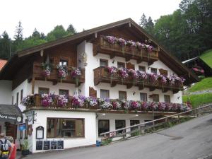 ein Gebäude mit Blumen auf den Balkonen in der Unterkunft Gasthof Und Hotel Maria Gern in Berchtesgaden