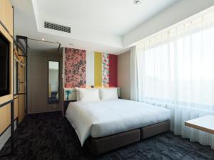 a bedroom with a white bed and a window at Mitsui Garden Hotel Kyoto Shijo in Kyoto