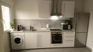 La cuisine est équipée de placards blancs, d'un évier et d'un lave-vaisselle. dans l'établissement Melia, à Hamm