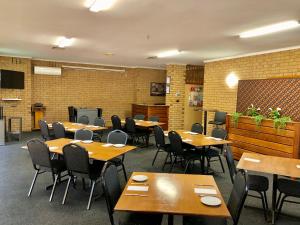 a dining room with wooden tables and chairs at Ararat Colonial Lodge Motel in Ararat