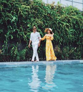 
a young girl and a young boy standing in a pool of water at Rosaleen Boutique Hotel in Hue
