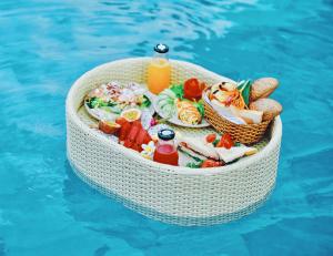 
a basket filled with food on top of a swimming pool at Rosaleen Boutique Hotel in Hue

