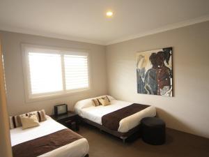 A bed or beds in a room at 339 Pacific Blue 265 Sandy Pt Road HUGE RESORT LAGOON POOL