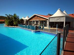a swimming pool in front of a house at Oaks Pacific Blue 339 Huge Resort Lagoon Pool in Salamander Bay