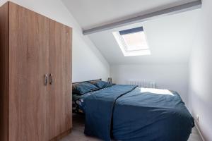 a bedroom with a bed and a wooden cabinet at Kelys Centre T2 Confort Moderne in Boulogne-sur-Mer