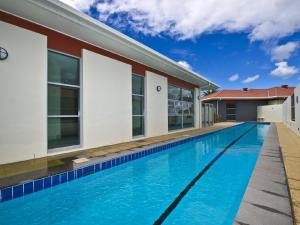 a swimming pool in front of a house at Oaks Pacific Blue 516 private pool aircon WI-FI in Salamander Bay