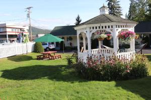 a white gazebo in a yard with flowers at The Heritage of Lake George in Lake George