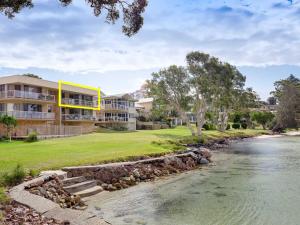 uma casa com um rio em frente em Pelican Sands 3 stunning waterfront unit with magical water views and air conditioning em Soldiers Point