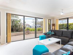 a living room with a couch and a table at Peninsula Waters 2 three bedroom unit with spacious private courtyard and WI-FI in Soldiers Point