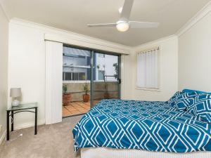 a bedroom with a blue bed and a window at Peninsula Waters 3 Beautiful Air Conditioned Unit with Pool Lift and WI-FI in Soldiers Point