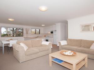 Sala de estar con 2 sofás y mesa en Promenade 11 air conditioned unit with beautiful water views en Shoal Bay