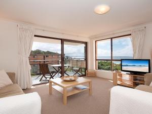 sala de estar con sofá y TV en Promenade 11 air conditioned unit with beautiful water views en Shoal Bay
