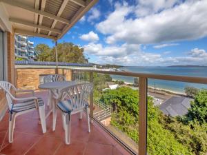 a balcony with a table and chairs and a view of the ocean at Quarterdeck 5 panoramic water views and close to town in Nelson Bay