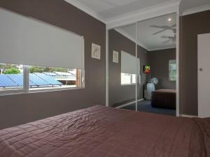 a bedroom with a large bed and a large window at Quarterdeck 5 panoramic water views and close to town in Nelson Bay