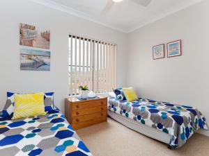1 Schlafzimmer mit 2 Betten, einer Kommode und einem Fenster in der Unterkunft Sailfish, 4,46 Magnus Street- Unit with water views and close to town in Nelson Bay
