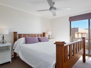 sypialnia z łóżkiem z fioletowymi poduszkami i oknem w obiekcie Skyline, 6,12 Thurlow Avenue - Unit with stunning views, Aircon and Wi-fi w mieście Nelson Bay