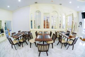 a dining room with wooden tables and chairs at The MACEO Hotel in Nong Khai